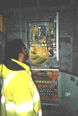 Technician calibrating gas analysis equipment inside a field enclosure